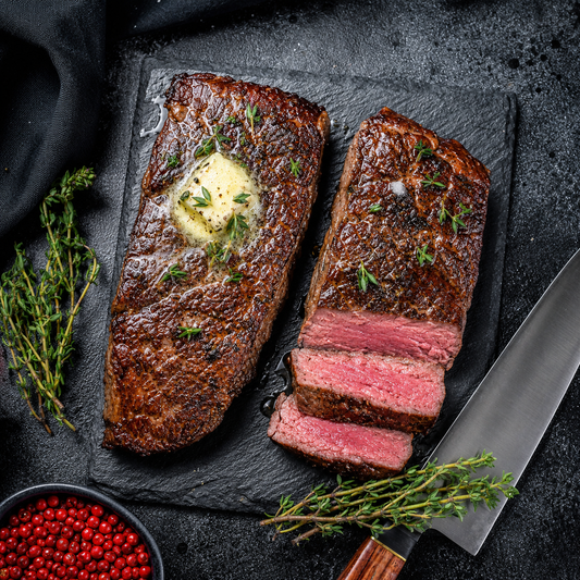 Grilled Denver steak sliced medium rare with herb butter from Diamond B Ranch